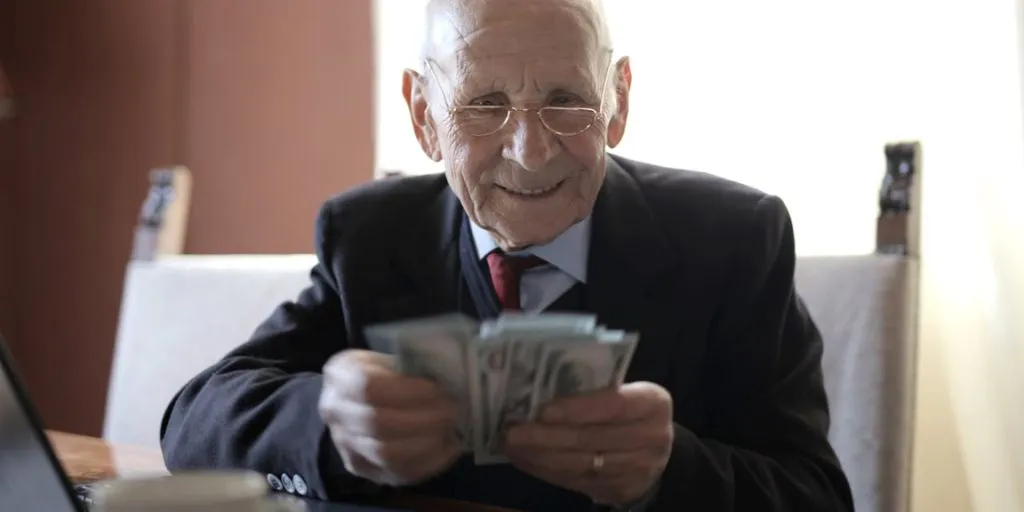 Jubilacion anticipada o la tradicional? En la imagen se puede ver un hombre mayor con una gran cantidad de dinero